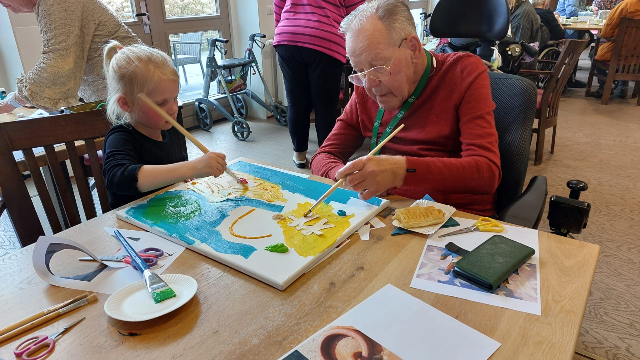 Ouderen en kind schilderen samen